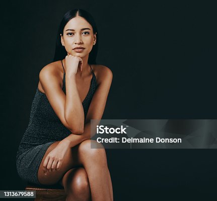 istock Shot of a beautiful young woman sitting against a black background 1313679588