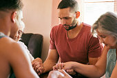 istock Shot of a family holding hands with eyes closed in prayer 1313851400