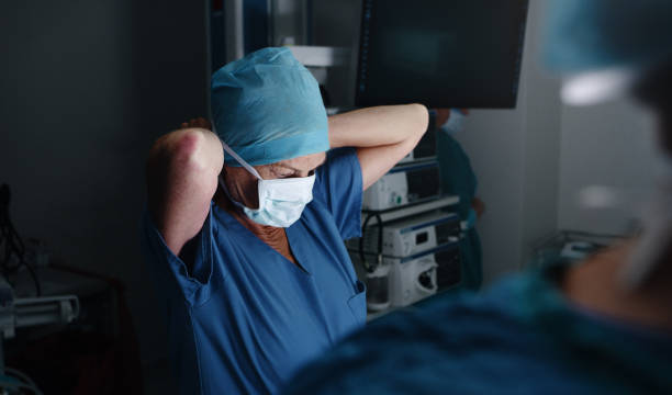 Shot of a female surgical nurse fastening her medical mask in the operating theatre stock photo