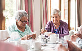 istock Shot of a group of senior women playing cards together at a retirement home 1341046988