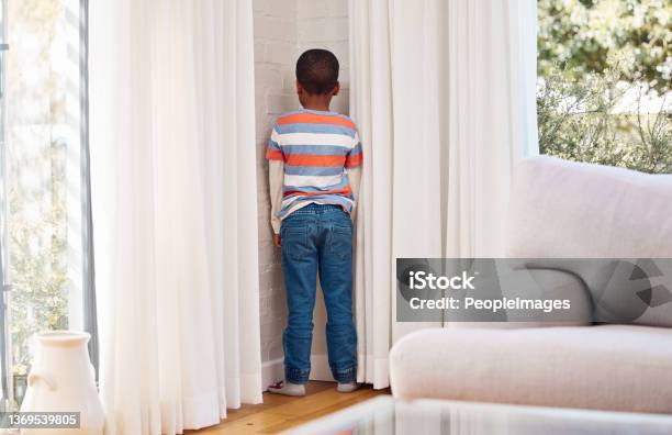 Shot of a little boy standing in the corner as a punishment at home