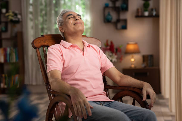 Shot of a mature man sitting on rocking chair at home:- stock photo stock photo
