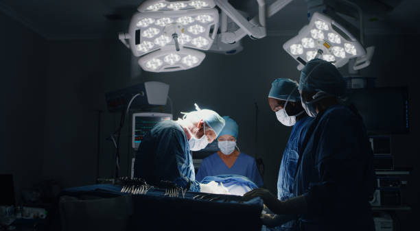 Shot of a medic team performing surgery in theatre stock photo