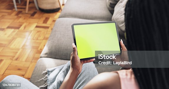 istock Shot of a unrecognizable woman using her tablet at home 1347838731