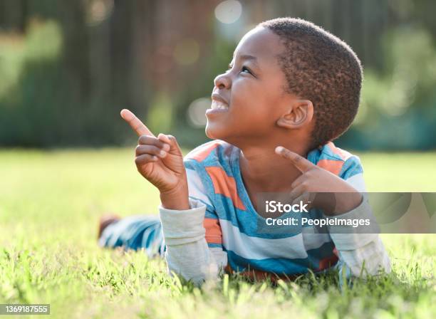 Shot of a young boy lying on the grass outside