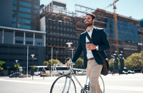 Shot of a young businessman traveling through the city with his bicycle stock photo