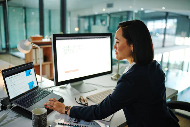 Shot of a young businesswoman using a computer in a modern office at work stock photo