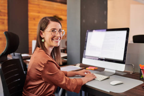 Shot of a young businesswoman using a computer in a modern office stock photo