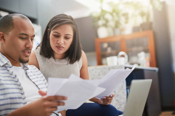 Shot of a young couple discussing paperwork at home stock photo