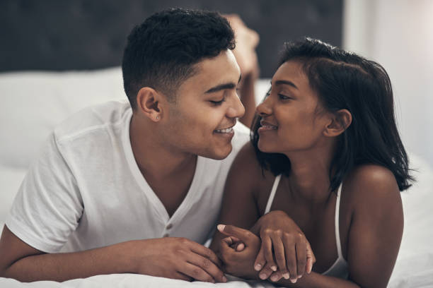 Shot of a young couple sharing an intimate moment at home happy couples onn bed stock pictures, royalty-free photos & images