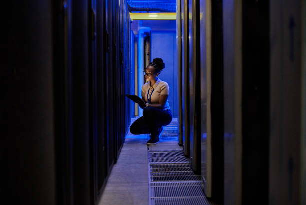 Shot of a young female engineer using a digital tablet while working in a server room stock photo