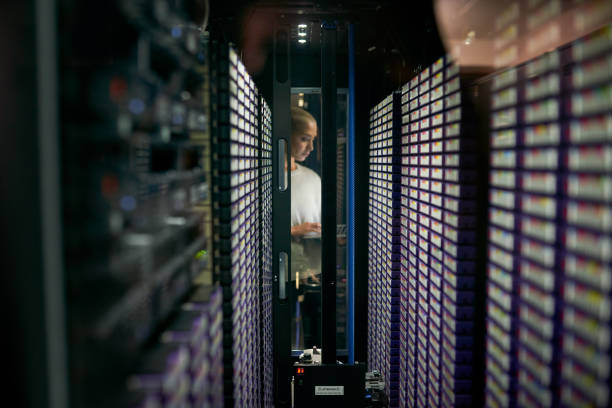 Shot of a young female engineer working in a server room stock photo