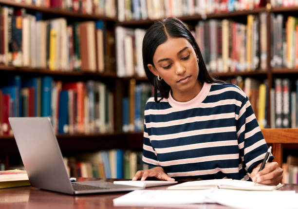 Shot of a young female student studying in a library at college Taking notes makes revising easier how to write a research paper without plagiarism stock pictures, royalty-free photos & images