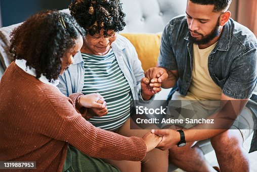 istock Shot of a young man and woman sitting on the sofa and holding hands at home 1319887953