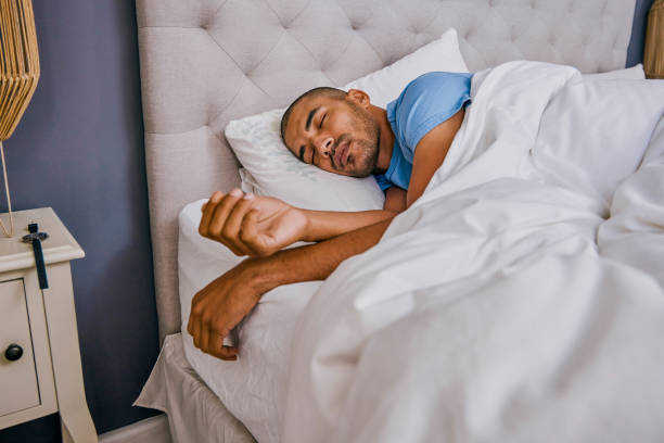 Shot of a young man sleeping in a bed at home stock photo