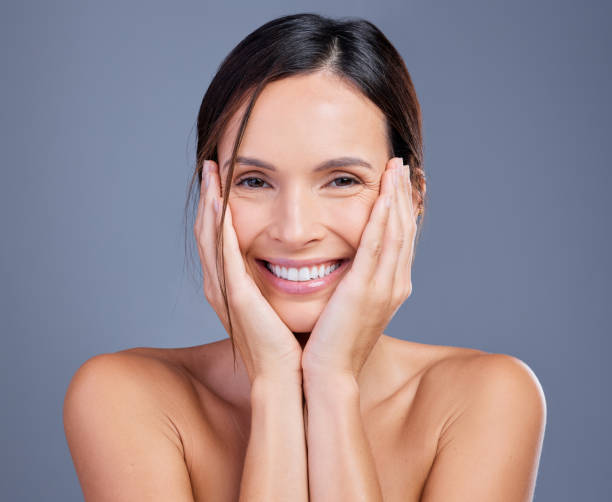 Shot of a young woman admiring her skin against a studio background Self love is an investment that always pays dividends beautiful fresh skin stock pictures, royalty-free photos & images