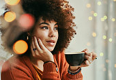 istock Shot of a young woman enjoying a cup of coffee in a cafe 1340874170