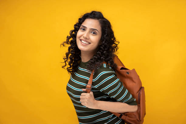 Shot of a young women standing isolated over yellow background stock photo