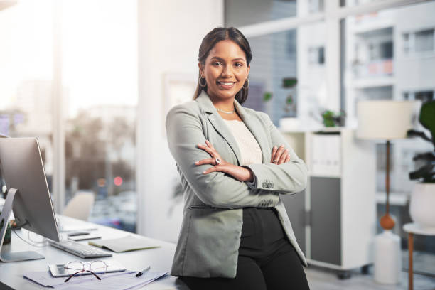Shot of an attractive young businesswoman standing in the office with her arms folded stock photo