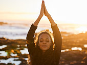 istock Shot of an attractive young woman doing yoga alone on the beach at sunset 1317735381