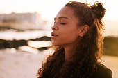 istock Shot of an attractive young woman sitting alone on a mat and meditating on the beach at sunset 1317735408