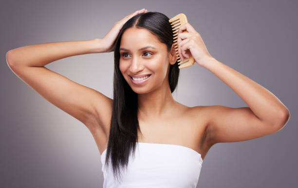 Shot of an attractive young woman standing alone in the studio and combing her hair Brushing the scalp stimulates hair growth detangle hair type stock pictures, royalty-free photos & images
