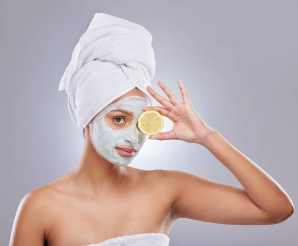 Shot of an attractive young woman wearing a face mask and holding a lemon in the studio Vitamin C is a must in a skincare routine Over-Exfoliating stock pictures, royalty-free photos & images