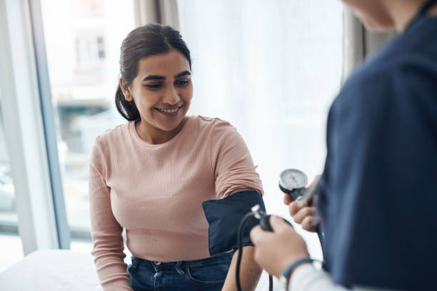 Shot of an unrecognizable doctor checking a patient's blood pressure in an office Your blood pressure is perfect visit stock pictures, royalty-free photos & images
