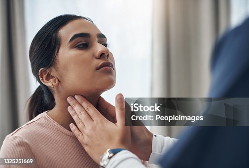 istock Shot of an unrecognizable doctor feeling a patient's throat in an office 1325251669