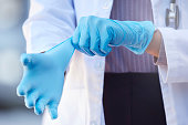 istock Shot of an unrecognizable doctor putting on surgical gloves outside 1349923613