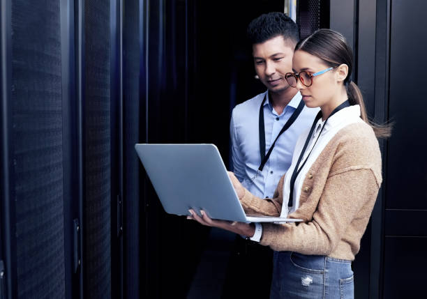 Shot of two technicians working together in a server room stock photo