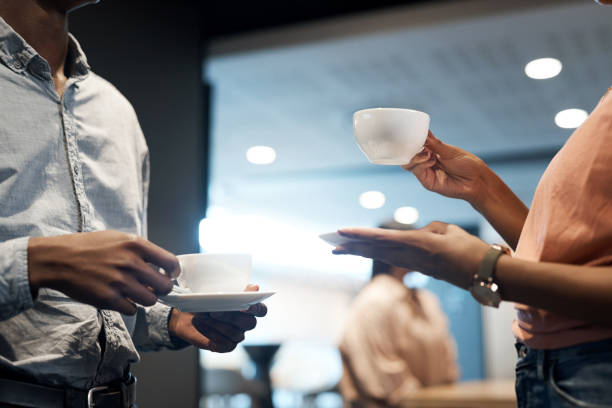 Shot of two unrecognisable businesspeople having coffee at a conference Tell me about your achievements over some tea coffee break stock pictures, royalty-free photos & images