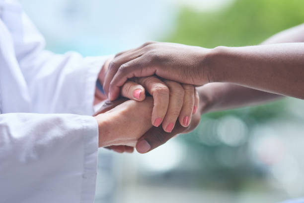 Shot of unrecognizable people holding hands Working together is how we'll get through this sad old black man stock pictures, royalty-free photos & images