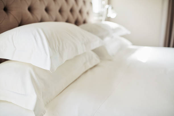 almohadas disparadas en una cama en un hotel moderno - camas fotografías e imágenes de stock