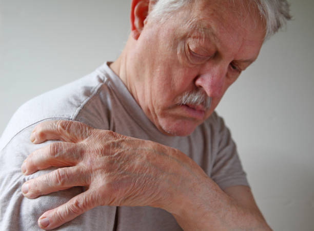 Shoulder joint pain on an older man stock photo
