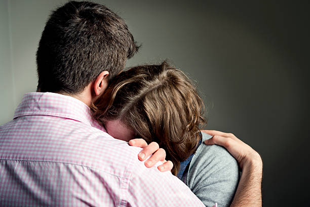 Shoulder To Cry On Couple embracing after receiving some bad news. mourner stock pictures, royalty-free photos & images