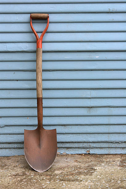 shovel on a blue wall stock photo