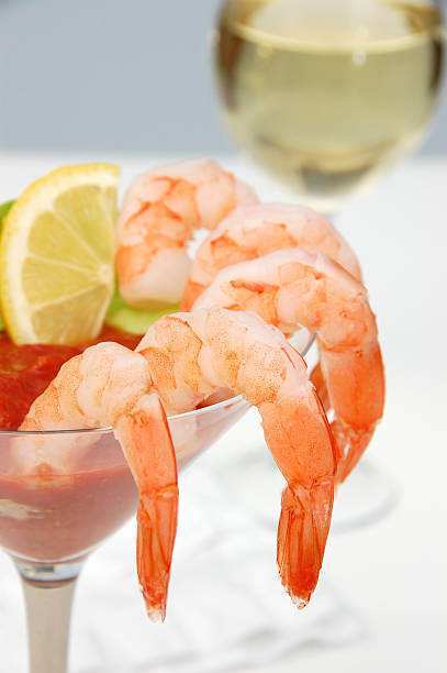 Shrimp Cocktail Shrimp cocktail elegantly served in a martini glass accompanied by a glass of white wine.Another image from this series: shrimp cocktail stock pictures, royalty-free photos & images