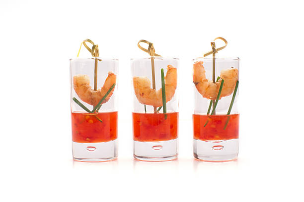 Shrimp in shot glasses with sweet and chili red sauce Shrimp in shot glasses with sweet and chili red sauce isolated on white. Party food. shrimp cocktail stock pictures, royalty-free photos & images