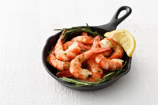 Shrimps in a skillet Tiger shrimps in a skillet cooking pan with cocktail sauce and seasoning shrimp cocktail stock pictures, royalty-free photos & images