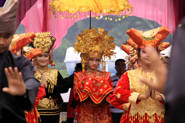 Shy traditional Minang dancer looking at crowd stock photo
