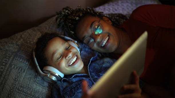 siblings die muziek luisteren gebruikend digitale tablet bij bed - kijken naar stockfoto's en -beelden
