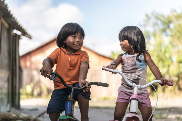 Siblings Riding a Bicycle in a Rural Place Beautiful shooting of how Brazilian Natives lives in Brazil south american culture stock pictures, royalty-free photos & images