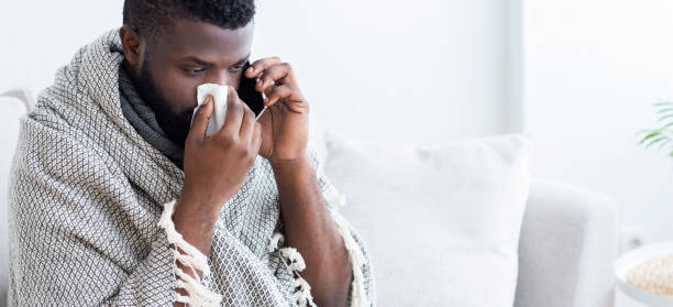 Sick black man calling on phone. to doctor Online consultation with doctor. Sick african man calling phone for medical help, suffering from cold and seasonal flu virus, empty space illness stock pictures, royalty-free photos & images