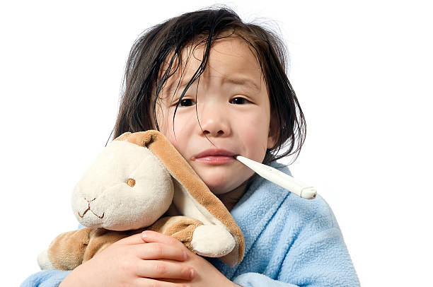 Sick child with fever and plush toy stock photo