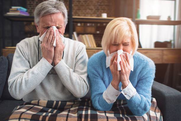 Sick couple are trying to sneeze in the napkin. They caught a co stock photo