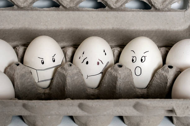 Sick Egg Among Other Eggs in the Egg Box stock photo