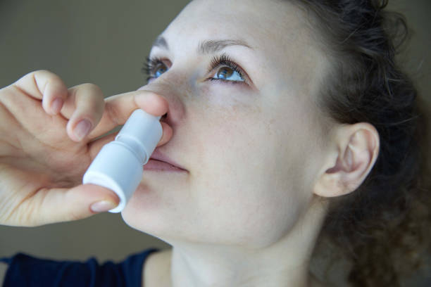sjuk flicka sprutar sprayen från rinnande näsa i näsan passera - runny or bildbanksfoton och bilder