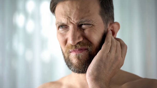 Sick guy feeling ear pain, health care, neurological infection, itchiness otitis stock photo