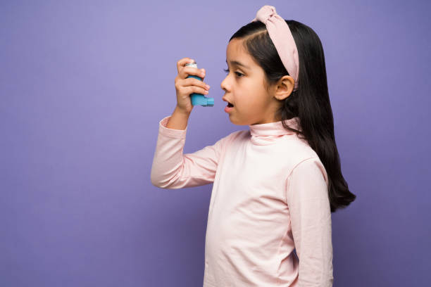 Sick little girl having an asthma attack stock photo